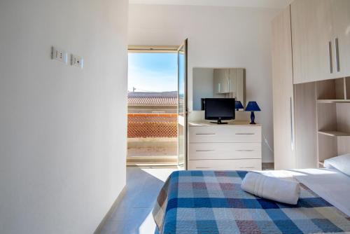 um quarto branco com uma cama e uma televisão em House Calabernardo Sea Beach - Sicilia Vacanza em Calabernardo