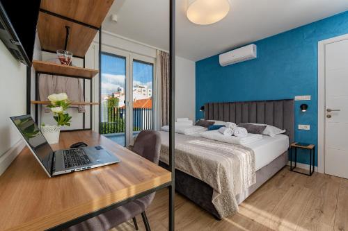 a bedroom with a bed and a desk with a laptop at Seven Seas Residence in Split