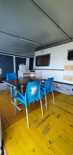 a dining room with a table and blue chairs at Camping Pilzone in Iseo