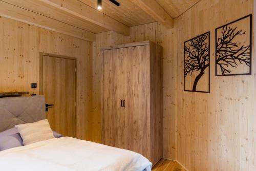 a bedroom with a bed and a wooden wall at Apartmán pod Demänovskou horou in Demanovska Dolina