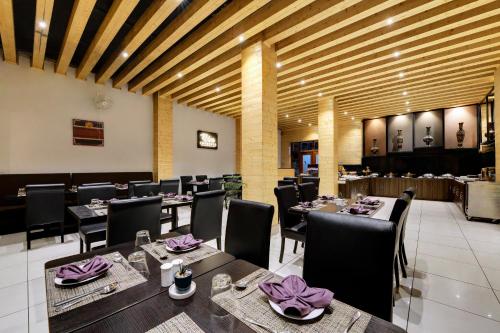 a dining room with tables and chairs with purple napkins at Sumitel Shangrila in Tādong