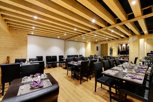a dining room with long tables and black chairs at Sumitel Shangrila in Tādong