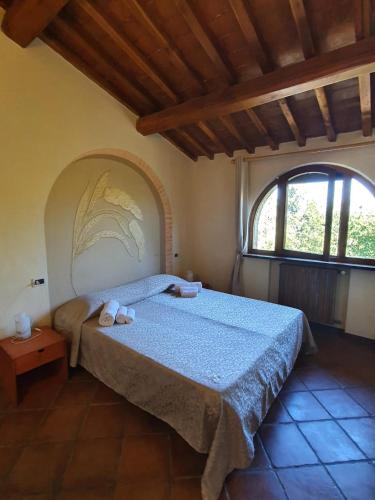 a bedroom with a bed in a room with a window at Agriturismo Fattoria Lischeto in Volterra