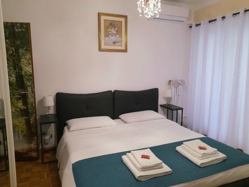 um quarto com uma grande cama branca com toalhas em Appartamento ospitale em Bolzano