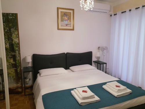 a bedroom with a large white bed with towels on it at Appartamento ospitale in Bolzano