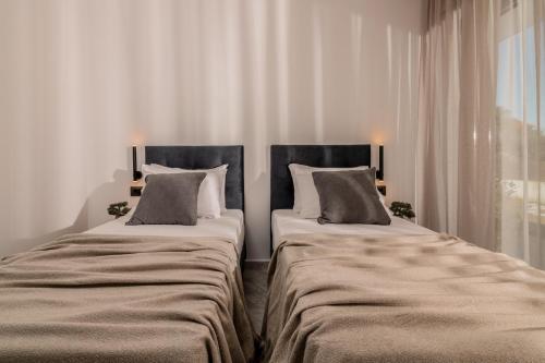 two beds sitting next to each other in a room at Armonia Boutique Hotel in Meson Yerakarion