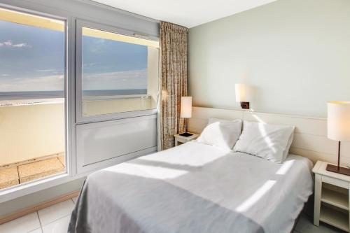 a bedroom with a bed and a large window at Belambra Clubs Saint-Jean-de-Monts - Les Grands Espaces in Saint-Jean-de-Monts