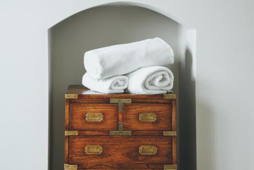 einen Haufen Handtücher auf der Kommode in der Unterkunft Maplewood Cottage, Wynyard Hall 