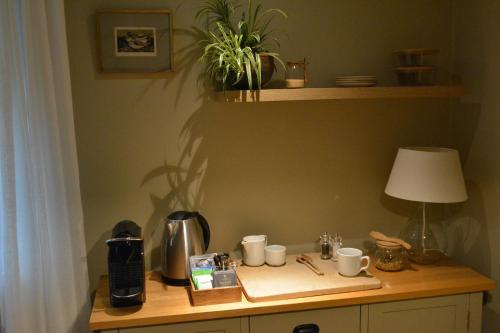 a table with coffee cups and a lamp on it at Beckside Cracoe in Skipton