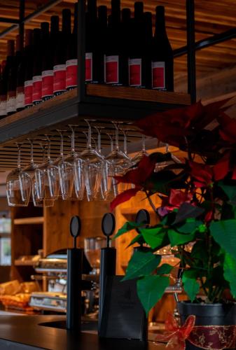 a bar with wine bottles and glasses on a shelf at Hotel Leonhard in Nova Ponente
