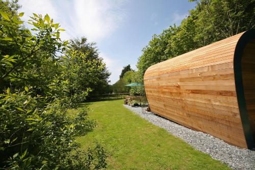 a garden with a wooden fence and grass at Sunridge EcoPod with Private Hot Tub in Plymouth