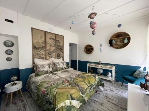 a bedroom with blue and white walls and a bed at La Maison Blanche de Lanton in Lanton