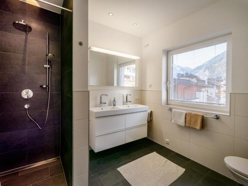 a bathroom with a sink and a shower and a toilet at Appartement Partoll in Mayrhofen