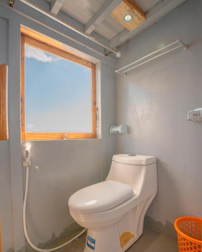 a bathroom with a toilet and a window at Open trip Labuan Bajo in Labuan Bajo