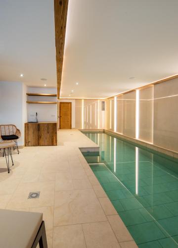 une piscine intérieure revêtue de carrelage vert et une piscine dans l'établissement Chalet Les Cochettes, à Courchevel