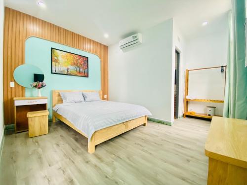 sypialnia z łóżkiem i obrazem na ścianie w obiekcie Moon's House Homestay Quy Nhơn w mieście Quy Nhơn