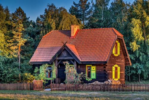 a small wooden house with a red roof at Kiermusy Dworek nad Łąkami in Kiermusy