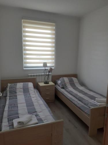 2 camas individuales en un dormitorio con ventana en Apartman Garic en Pale