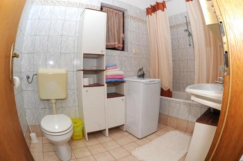 La petite salle de bains est pourvue de toilettes et d'un lavabo. dans l'établissement Holiday Home Maya, à Medulin