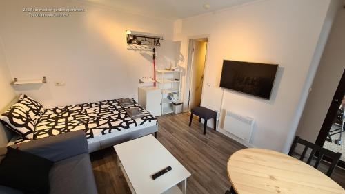 - un petit salon avec un lit et une table dans l'établissement Refurbished studios, mountain view balconies, minutes from gondola, à Bansko