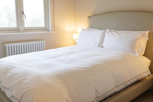 un grande letto bianco in una camera da letto con finestra di The Olive Apartment - Greentrees Estate a Haywards Heath