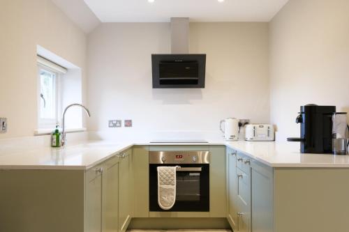 a kitchen with a sink and an oven in it at The Olive Apartment - Greentrees Estate in Haywards Heath