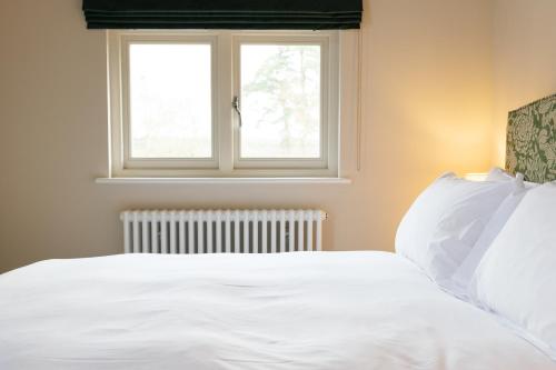 1 dormitorio con 1 cama blanca y ventana en The Olive Apartment - Greentrees Estate, en Haywards Heath