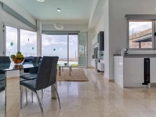 a kitchen and dining room with a table and chairs at Villa Calm Ocean views by Infinity Summer in La Playa de Arguineguín
