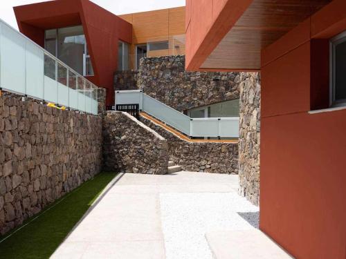 an external view of a building with a stone wall at Villa Calm Ocean views by Infinity Summer in La Playa de Arguineguín