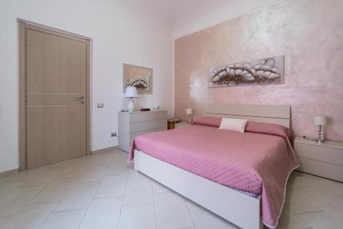 a bedroom with a bed with a pink blanket at Casa Maria in La Maddalena