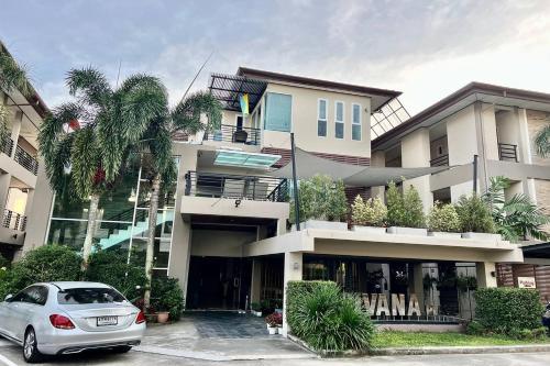 een witte auto geparkeerd voor een gebouw bij Sivana Place Phuket in Bang Tao Beach