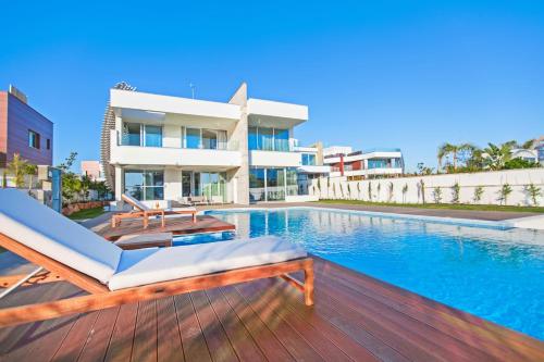 a swimming pool in front of a house at Vivo Mare Beachfront Villas - Emerald in Ayia Napa