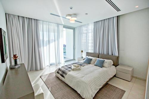 ein Schlafzimmer mit einem großen Bett und großen Fenstern in der Unterkunft Vivo Mare Beachfront Villas - Emerald in Ayia Napa