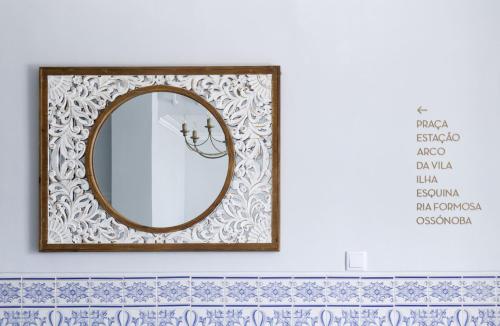 espejo con marco de madera en la pared en Palacete da Baixa by MY CHOICE en Faro