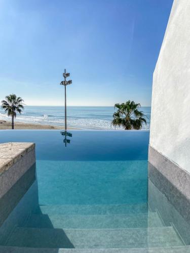 a swimming pool with a cross in the middle of the ocean at Cádiz Bahía by QHotels in Cádiz