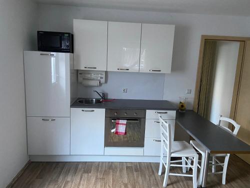 a kitchen with white appliances and a table and chairs at Schöne & ruhige Ferienwohnung in Pfullingen