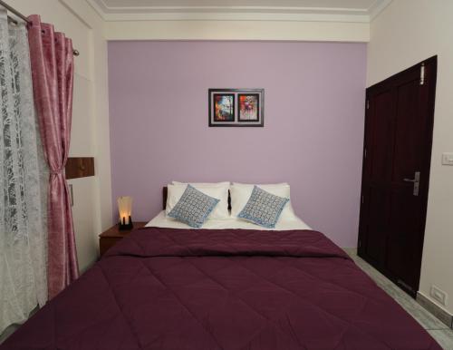 a bedroom with a bed with purple sheets and pillows at AVANTI CASTELLO in Guruvāyūr