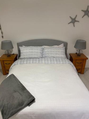 a bedroom with a white bed with two night stands at No. 19 in Rostrevor