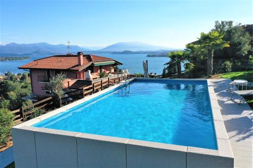 a large swimming pool in front of a house at Penthouse Andrea in Meina