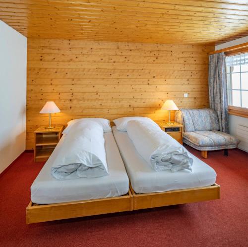 a bedroom with two beds in a wooden room at Hotel und Restaurant Chäseren in Schönengrund