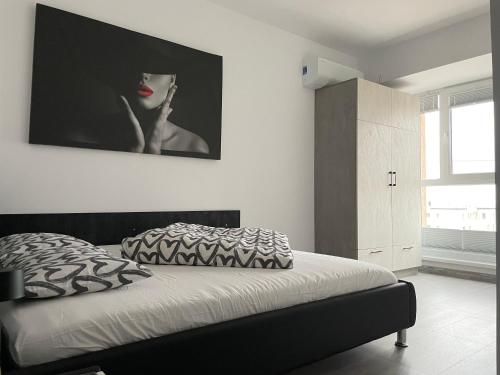 a bedroom with a bed with a picture on the wall at Beautiful Penthouse Lakeview W18 in Bucharest