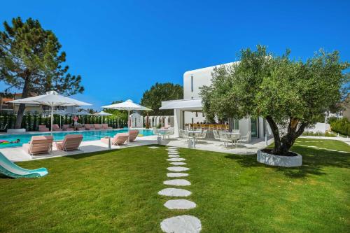 un patio con una piscina con un árbol y sillas en Cocoοns Luxury Suites & Villas en Fourka