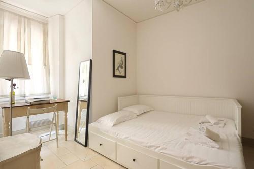 Schlafzimmer mit einem Bett, einem Schreibtisch und einem Spiegel in der Unterkunft Belle Donne Historical Apartment - City Center in Florenz
