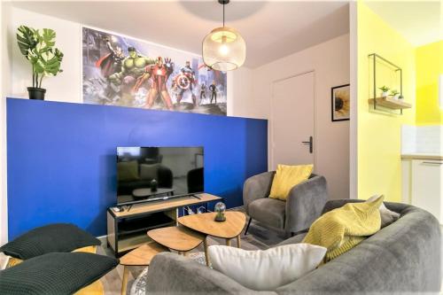 een woonkamer met een blauwe accentmuur bij Appart Disney T3 Sweet place in Montévrain