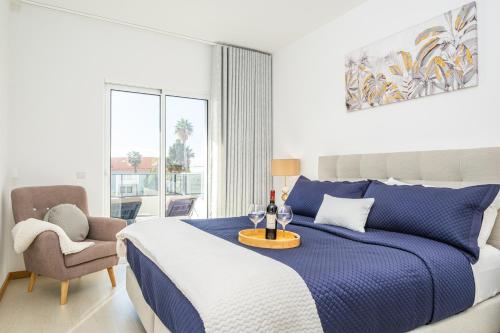 a bedroom with a blue and white bed and a chair at Blue Paradise Apartment in Caniço