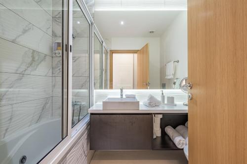 a bathroom with a tub and a sink and a shower at Blue Paradise Apartment in Caniço