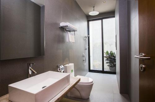關丹的住宿－斯萊馬酒店，浴室配有白色水槽和卫生间。