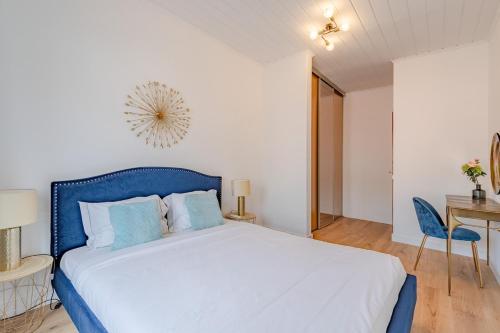 a bedroom with a blue bed and a table and a desk at Setúbal Oasis House in Setúbal