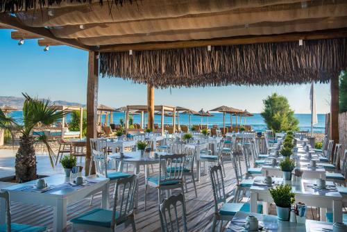 a table set up for a wedding on the beach at Paralos Lifestyle Beach Adults Only in Amoudara Herakliou
