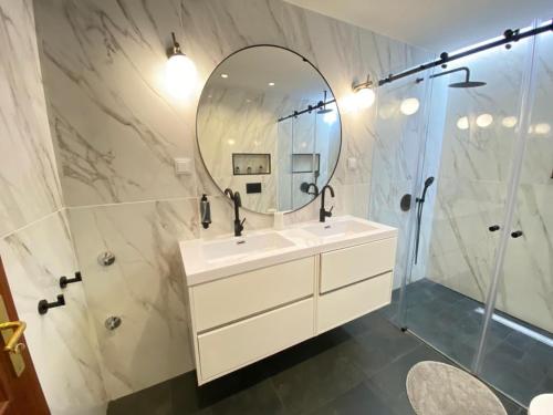 a bathroom with a sink and a mirror at Setúbal Oasis House in Setúbal